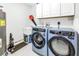 Well-lit laundry room with blue washer/dryer, sink, and storage cabinets at 750 4Th Avenue South # 601H, St Petersburg, FL 33701