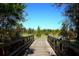 Picturesque wooden boardwalk providing access to a verdant and open space with clear sky at 7770 Painted Sky Pl, Land O Lakes, FL 34637