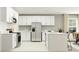 Modern kitchen with white cabinets, stainless steel appliances, and an island, offering ample workspace at 7770 Painted Sky Pl, Land O Lakes, FL 34637