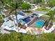 Stunning aerial view of home with solar panels, pool, lush landscaping, and outdoor deck at 7906 Bayshore Dr, Seminole, FL 33776