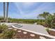 Spacious outdoor deck with stairs and seating, complemented by lush, tropical foliage at 7906 Bayshore Dr, Seminole, FL 33776