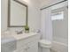 Clean bathroom featuring a white vanity, toilet, and shower with a white shower curtain at 7906 Bayshore Dr, Seminole, FL 33776