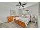 Bright bedroom with a ceiling fan, artwork, and a wooden dresser and bed frame at 7906 Bayshore Dr, Seminole, FL 33776