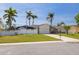 Charming single-story home featuring a lush lawn, white picket fence, and a screened-in lanai for outdoor enjoyment at 7906 Bayshore Dr, Seminole, FL 33776