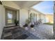 Inviting front porch with slate tile, stylish seating, decorative plants, and a welcoming entrance door at 7906 Bayshore Dr, Seminole, FL 33776