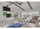 Open-concept living room featuring a fireplace, vaulted ceilings with wood beams, and seamless access to the kitchen and dining area at 7906 Bayshore Dr, Seminole, FL 33776