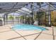 Screened-in pool area with a pool, trees, and a patio at 7906 Bayshore Dr, Seminole, FL 33776