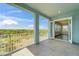 Spacious tiled balcony with white railing and ample views overlooks verdant landscape, blending indoor-outdoor living seamlessly at 814 Manns Harbor Dr, Apollo Beach, FL 33572