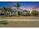 Charming two-story home with a light blue exterior, featuring lush tropical landscaping and a beautiful sunset backdrop at 814 Manns Harbor Dr, Apollo Beach, FL 33572