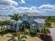 Stunning two-story home featuring lush tropical landscaping and a stylish light blue facade with stone accents at 814 Manns Harbor Dr, Apollo Beach, FL 33572