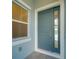 Stylish blue front door with a sidelight and a modern window showcasing natural light at 814 Manns Harbor Dr, Apollo Beach, FL 33572