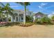Well-manicured front yard showcasing the beautiful light blue exterior and lush tropical landscaping at 814 Manns Harbor Dr, Apollo Beach, FL 33572