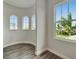 Bright hallway features arched windows, wood floors, and neutral paint, offering natural light and pleasing architectural details at 814 Manns Harbor Dr, Apollo Beach, FL 33572