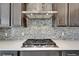 Close-up of a modern kitchen featuring a stainless range hood and tile backsplash at 814 Manns Harbor Dr, Apollo Beach, FL 33572