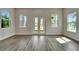Sunlit living room with gray floors, white trim, and view of tropical landscape at 814 Manns Harbor Dr, Apollo Beach, FL 33572