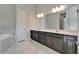 Bright bathroom featuring vanity with dual sinks, a large mirror, and marble floors at 814 Manns Harbor Dr, Apollo Beach, FL 33572