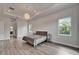 Bright main bedroom featuring two bedside tables, hardwood floors, and decorative lighting at 814 Manns Harbor Dr, Apollo Beach, FL 33572
