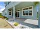 The covered patio features stone flooring with views of the landscaped backyard and garden at 814 Manns Harbor Dr, Apollo Beach, FL 33572