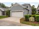 Two-story gray home with a two car garage, white doors and trimmed landscaping at 9106 Crystal Commons Way, Tampa, FL 33626