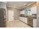 A bright kitchen featuring stainless steel appliances, white cabinets, and tile flooring at 9106 Crystal Commons Way, Tampa, FL 33626