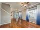 Spacious living room with hardwood floors, ceiling fans, and large windows with blue curtains at 9106 Crystal Commons Way, Tampa, FL 33626