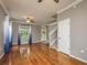 Living room showcasing hardwood floors, a ceiling fan, a staircase, and large windows with blue curtains at 9106 Crystal Commons Way, Tampa, FL 33626