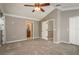 Main bedroom features plush carpet, a ceiling fan, and access to an ensuite bathroom and closet at 9106 Crystal Commons Way, Tampa, FL 33626
