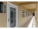 Condo entryway featuring a white door with decorative glass, modern lighting and hallway access at 1 Boca Ciega Point Blvd # 212, St Petersburg, FL 33708