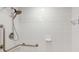 Accessible shower with white tiles, grab bars, and a handheld shower head at 1 Boca Ciega Point Blvd # 212, St Petersburg, FL 33708