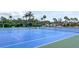 Bright blue and green tennis court surrounded by palm trees, perfect for recreational activities and enjoying sunny days at 1 Boca Ciega Point Blvd # 212, St Petersburg, FL 33708