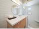 Bright bathroom with white tile, a round mirror, a floating vanity, and a glass-enclosed shower at 10 Brightwaters Ne Cir, St Petersburg, FL 33704