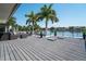 Waterfront deck with sleek outdoor furniture, glass railings, and lovely palm tree views overlooking the canal at 10 Brightwaters Ne Cir, St Petersburg, FL 33704