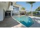 Exterior pool view of home with floor to ceiling windows and sliding glass doors at 10 Brightwaters Ne Cir, St Petersburg, FL 33704