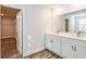 Elegant bathroom with double sinks, granite countertops, and an open walk-in closet at 10025 Surrey Rose Dr, San Antonio, FL 33576
