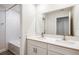 Bright bathroom featuring double vanity, quartz countertop, and bath with textured tile at 10025 Surrey Rose Dr, San Antonio, FL 33576
