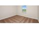 This bedroom has neutral walls, a window, base molding, and brown carpeting at 10025 Surrey Rose Dr, San Antonio, FL 33576