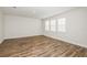 Bright, open bedroom featuring wood flooring and three large windows at 10025 Surrey Rose Dr, San Antonio, FL 33576