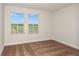 Bright bedroom featuring neutral carpet, white walls, and two windows offering ample natural light at 10025 Surrey Rose Dr, San Antonio, FL 33576