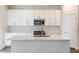 Modern kitchen featuring a center island, white cabinets, quartz countertops and stainless steel appliances at 10025 Surrey Rose Dr, San Antonio, FL 33576