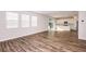 Open concept living room showing wood floors and access to a kitchen and outdoor patio at 10025 Surrey Rose Dr, San Antonio, FL 33576