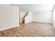 Spacious living room showcasing wood floors and staircase, filled with natural light from multiple windows at 10025 Surrey Rose Dr, San Antonio, FL 33576