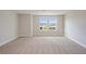 Spacious carpeted bedroom with two large windows offering a neighborhood view and ample natural light at 10037 Surrey Rose Dr, San Antonio, FL 33576