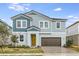 Charming two-story home features a yellow front door, brick driveway, and manicured landscaping at 10037 Surrey Rose Dr, San Antonio, FL 33576