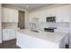 Modern kitchen features white cabinets, a quartz island, and stainless steel appliances at 10037 Surrey Rose Dr, San Antonio, FL 33576
