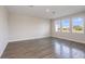 Bright, empty living room with three large windows and hardwood flooring at 10037 Surrey Rose Dr, San Antonio, FL 33576