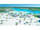 Picturesque aerial showcasing white sand beach, aqua blue swimming area, palms, lounge chairs, and lakeside dining at 10049 Surrey Rose Dr, San Antonio, FL 33576