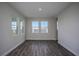 Bright, airy living room featuring dark wood floors and several windows offering natural light at 10243 Fieldstone Myrtle Way, San Antonio, FL 33576