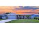 Charming single-Gathering home with a well-manicured lawn and cozy front porch seating area under a beautiful sunset sky at 10884 118Th St, Seminole, FL 33778