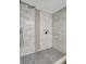 Detailed view of shower with unique tile, hexagon flooring, shower niche and brushed steel hardware at 10884 118Th St, Seminole, FL 33778
