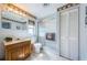 Full bathroom with a shower, a wooden vanity, a large mirror and white tiled floors at 11831 104Th Ln, Largo, FL 33773